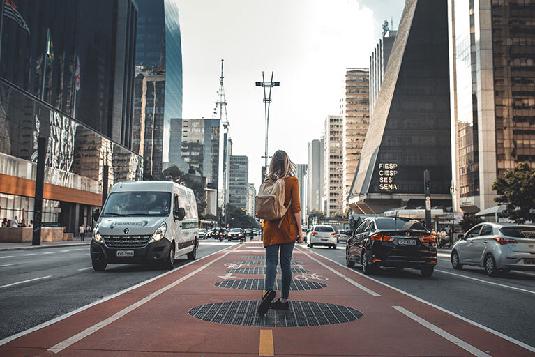 Frau läuft durch die Straße einer Großstadt